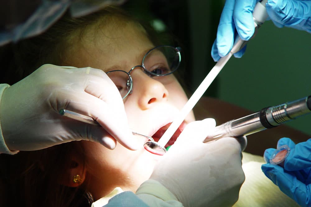 Dr. Mina elahi inspecting a childs teeth