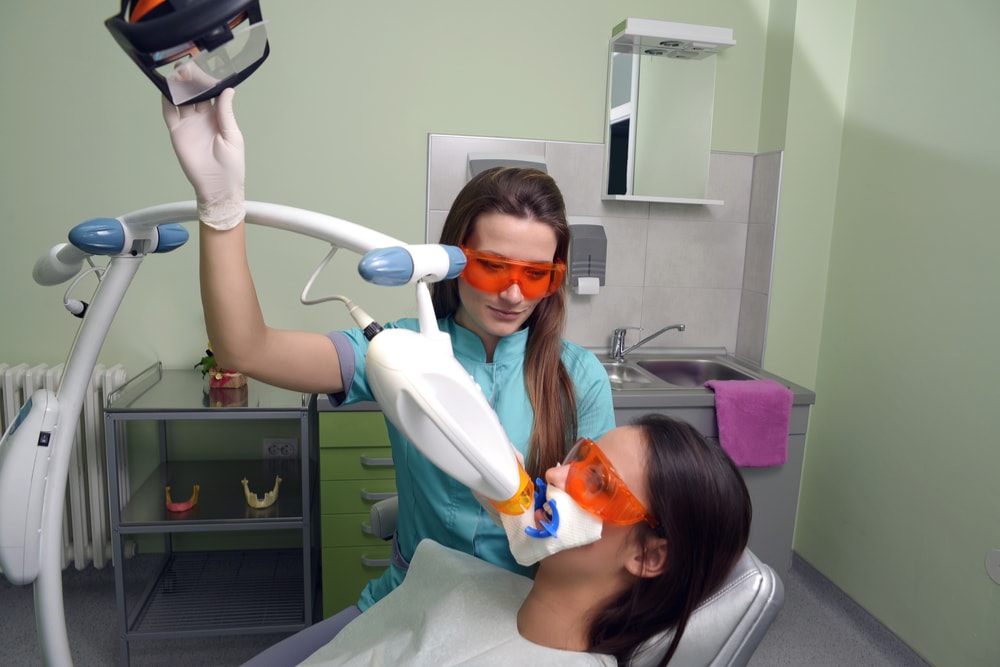 In office dental procedure with light source device irradiating teeth whitening gel