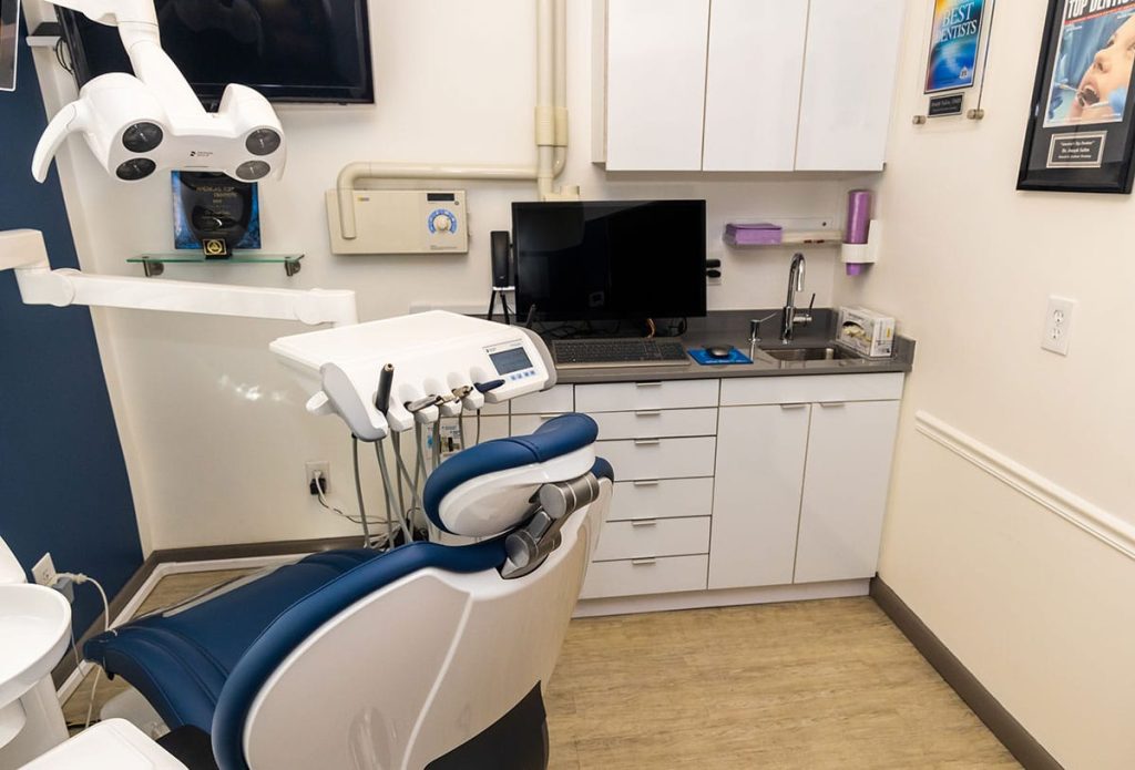 Dental chair with dental equipment in exam room.