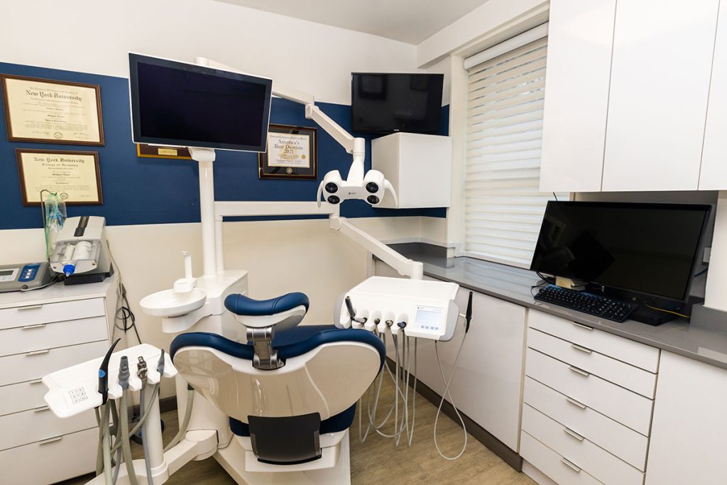 Dental chair with dental equipment in exam room.