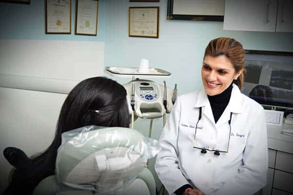 Female dentist smiling at her female patient.